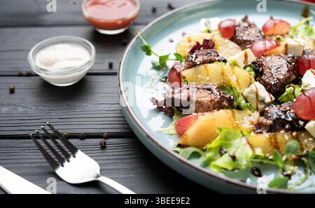 Warmer Salat mit Hühnerleber, reifer Birne, Blauschimmelkäse, frischen Kräutern, Salat, und Balsamico-Glasur. Serviert auf Teller. Konzept des Gourmet-Restaurants m Stockfoto