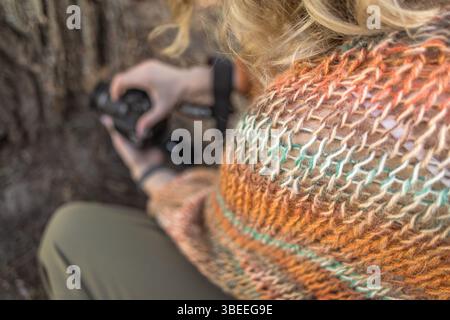 Farbenfrohe Strickjacke aus Mohair in warmen Farben mit einem Knäuel Garn. Strickmode. Herbst- und Wintergarderobe. Gemütliches Zuhause. Warme Sachen. Handwerkliches Produkt Stockfoto