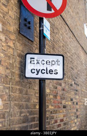 Ein Straßenschild in London, das anzeigt, dass der Zutritt mit Ausnahme von Fahrrädern an einer Ziegelmauer verboten ist. Stockfoto