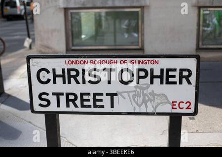 Straßenschild für Christopher Street in Islington, London, mit Graffiti. Das Schild befindet sich an einer Straße mit städtischer Umgebung. Stockfoto