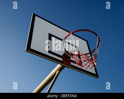 Niedriger Winkel des Basketballkörpers und der Rückseite vor klarem blauem Hintergrund Stockfoto