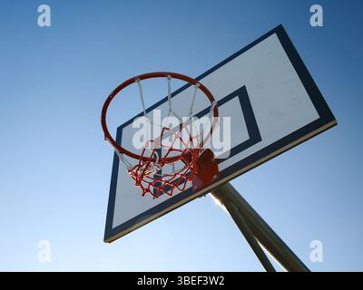 Niedriger Winkel des Basketballkörpers und der Rückseite vor klarem blauem Hintergrund Stockfoto