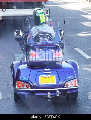 Straßenverkehr Straße Szene zurück blaues Honda Trike Motorrad mit GB Landschild steht hinter LKW in der Warteschlange Chester Cheshire England Großbritannien Stockfoto