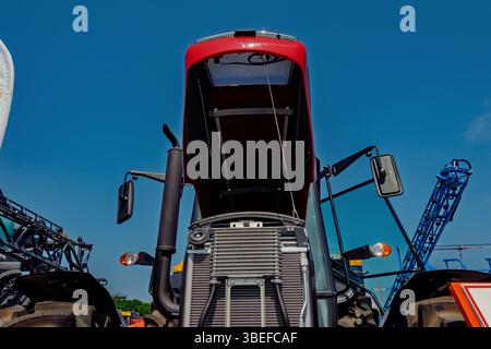 Nahaufnahme-Landwirtschaftstraktor mit offener Haube und blauem Himmel als Hintergrund am sonnigen Tag. Stockfoto