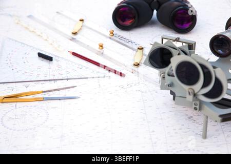Navigationstools befinden sich auf der Navigationskarte. Sextant, Plotter, Teiler, Lineal und Fernglas. Stockfoto