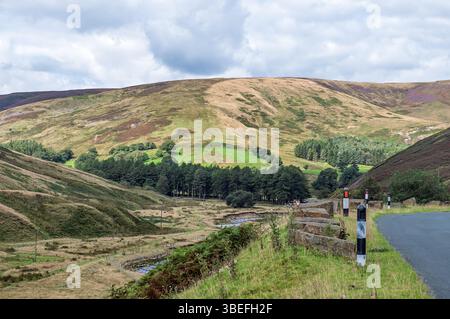 Malerischer Blick auf ein Tal im Trog von Bowland mit einem Fluss, der durch das Tal fließt, aus der Perspektive der Straße an einem bewölkten Tag. Stockfoto