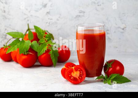 Tomatensaft im Glas und frische Tomaten Stockfoto