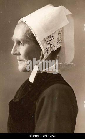 Dieses Porträt aus der Guiler Femme Collection, um 1940, zeigt eine ältere Frau aus Guiler-sur-Goyen in traditioneller Kleidung. Die Untertanin Marie-Catherine Jannic wurde 1870 geboren und verstarb 1945. Das Bild zeigt ihr kulturelles Erbe und die traditionelle Kleidung der Region. Stockfoto