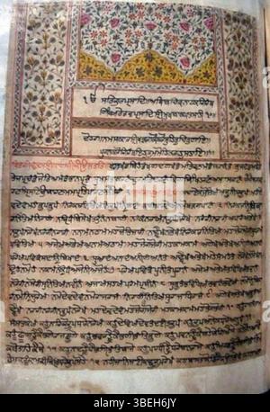 Seite aus einer kombinierten Adi-Dasam Granth Manuskript, die Bhai Mani Singh um 1713 zugeschrieben wurde, mit roter und schwarzer Kalligraphie, floralen Randdekorationen und einzigartigen Textelementen. Stockfoto