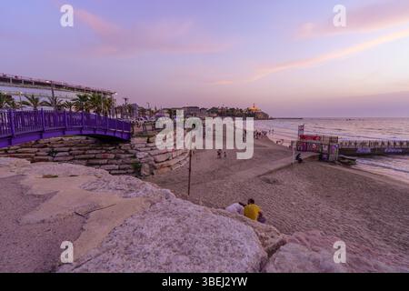 Tel-Aviv, Israel - 16. Mai 2025: Sonnenuntergang auf die Küstenpromenade und das alte Jaffa mit Einheimischen und Besuchern. Tel-Aviv-Yafo, Israel Stockfoto