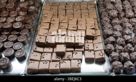 In einer Chocolatery oder einem Coffee Shop finden Sie eine große Auswahl an hauseigenen Pralinen und eine Auswahl an dunklen Runden mit einem Drall oben Stockfoto