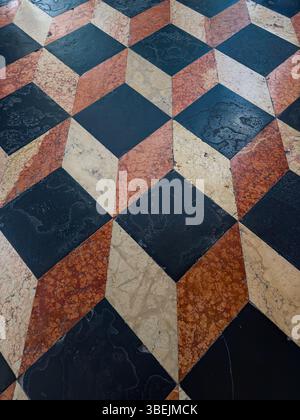 Farbenfroher Marmorboden in der alten Kirche mit weißen, orangen und schwarzen Fliesen Stockfoto