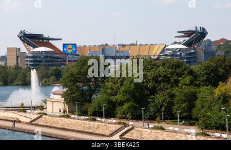 Pittsburgh, Pennsylvania, USA - 8. August 2023: Pittsburgh Football Stadium, umgeben von Grün, das an einem sonnigen Tag die malerische Uferpromenade reflektiert. Stockfoto