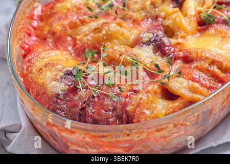 Gebackene Süßkartoffel, Pastinaken und Rote-Rüben-Gratin, gewürzt mit frischem Thymian und garniert mit geschmolzenem Käse, horizontale Nahaufnahme Stockfoto
