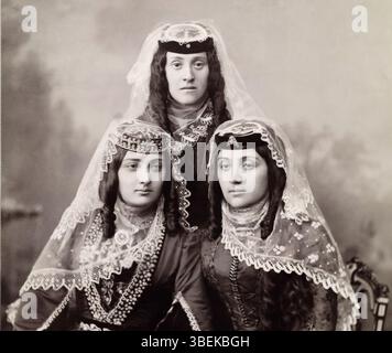 Drei georgische Frauen in feiner traditioneller Kleidung posieren für ein Porträt. Stockfoto
