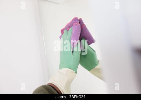 Reinigungsprozess mit Handschuhen und Tüchern in einem hellen Raum Stockfoto