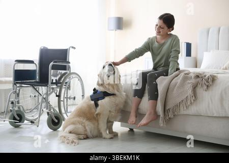 Mädchen mit Behinderung und ihr Diensthund zu Hause Stockfoto