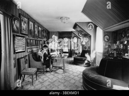 Das Foto von Elfelts Fotoatelier aus dem Jahr 1935 zeigt ein Auto, das am Eingang eines Gebäudes geparkt ist. Das Bild zeigt die Mode der damaligen Zeit im Automobildesign und in der Architektur. Stockfoto