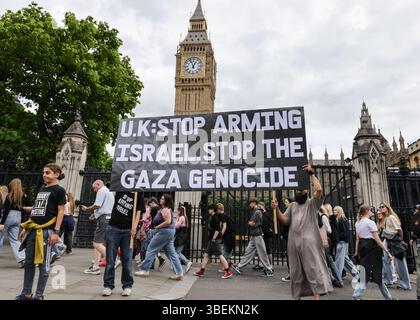 London, Großbritannien. Mai 2025. Demonstranten und Aktivisten verschiedener Organisationen, darunter Choose Love, das International Jewish Antizionist Network und Fußball gegen Apartheid-Kundgebung mit Plakaten und Fahnen vor dem Parlament in Westminster. Ein ausgesuchter Love-Demonstrant liest die Namen palästinensischer Kinder vor, die im Konflikt getötet wurden. Quelle: Imageplotter/Alamy Live News Stockfoto