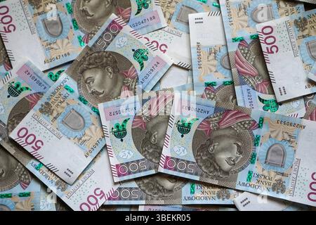 Verstreute 500 Zloty-Banknoten mit einem klaren Porträt des Königs und bildeten ein dynamisches Mosaik aus bewegtem Geld. Stockfoto