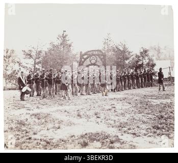 Dieses Foto, das Mathew B. Brady zugeschrieben wird, zeigt die Kompanie A der 30. Pennsylvania-Infanterie, die von Captain Mott Hooton während des Amerikanischen Bürgerkriegs (1861–1865) kommandiert wurde. Die Soldaten werden in ihrer Kriegsausrüstung gefangen genommen und zeigen die Militärkleidung und die düstere Stimmung der Ära. Stockfoto