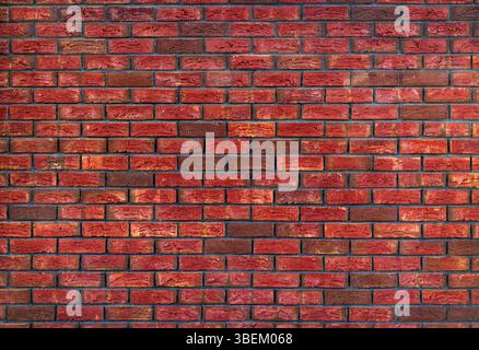 Wandstruktur Aus Rotem Ziegelstein. Eine detaillierte Nahaufnahme einer roten Ziegelwand, die die reichen Texturen und Farben der Ziegelsteine zeigt. Stockfoto
