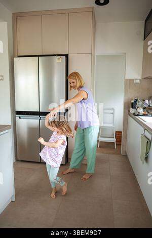 Fröhliche Momente des Tanzens in einer gemütlichen Küche mit der Familie Stockfoto