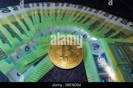 Goldene Bitcoin-Kryptowährungsmünze auf 100-Euro-Scheinen. Goldene Bitcoin-Kryptowährungsmünze auf 100-Euro-Scheinen. Bitcoin-Münzen und Bargeld-Hintergrund. *** Los Stockfoto