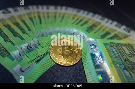 Goldene Bitcoin-Kryptowährungsmünze auf 100-Euro-Scheinen. Goldene Bitcoin-Kryptowährungsmünze auf 100-Euro-Scheinen. Bitcoin-Münzen und Bargeld-Hintergrund. *** Los Stockfoto