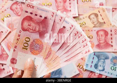 Großer Stapel verschiedener chinesischer Yuan-Banknoten 100 in Hand. Chinesische Papierwährung Yuan-Renminbi-Banknoten und -Münzen. Kopierbereich. Nahaufnahme. Stockfoto