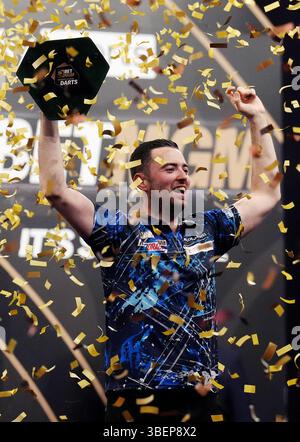 Luke Humphries feiert mit der Trophäe, nachdem er das Finale gegen Luke Litttler während der BetMGM Premier League Play-offs im O2, London gewonnen hat. Bilddatum: Donnerstag, 29. Mai 2025. Stockfoto