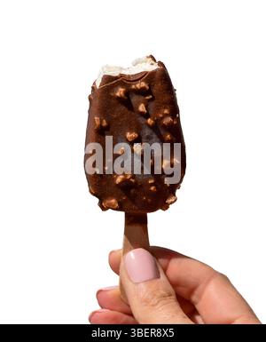 Die Frauenhand hält Schokolade mit Nüssen überzogenes Vanilleeis mit einem Biss an der Oberseite isolierter Ausschnitt auf weiß Stockfoto