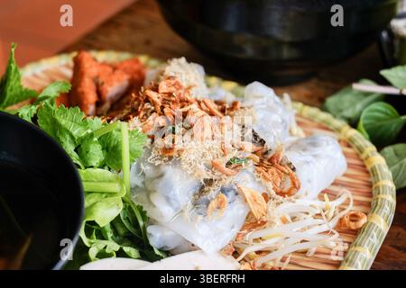 Banh Cuon nach Hanoi-Art, Reisnudelrollen mit gemahlenem Schweinefleisch, serviert mit Cha lua (Wurst), frischen Kräutern und nuoc cham Dipping Sauce im VN Street Foods Stockfoto