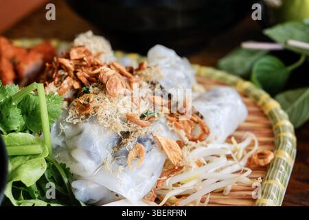 Banh Cuon nach Hanoi-Art, Reisnudelrollen mit gemahlenem Schweinefleisch, serviert mit Cha lua (Wurst), frischen Kräutern und nuoc cham Dipping Sauce im VN Street Foods Stockfoto