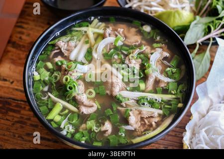 Im VN Street Foods, einem nordvietnamesischen Street Food Restaurant im inneren Westen Sydneys, wird eine Schüssel mit Rindfleisch nach Hanoi-Art Pho Tai lan mit frischen Kräutern serviert Stockfoto