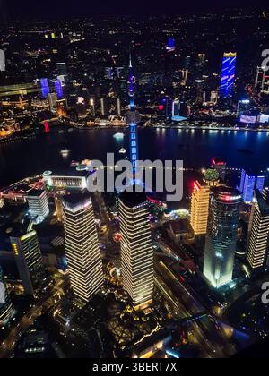 Shanghai, China - 1. April 2025: Vertikaler Nachtanblick vom Shanghai Tower aus mit beleuchteter Skyline, Huangpu River und Oriental Pearl Tower in Vibran Stockfoto