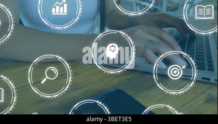 Abbildung: Herabfallende Bildsymbole über die Person, die ein Notebook verwendet Stockfoto