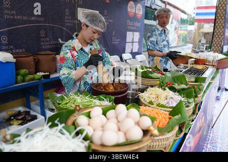 Händler machen thailändische Küche beim 15. Thai Festival in Kunming. Kunming, China. 29. Mai 2025. Das 15. Thai Festival in Kunming, südwestchinesischer Provinz Yunnan, beginnt am 29. Mai 2025. Die thailändischen Kulturveranstaltungen und die thailändische Messe zogen viele Bürger und Touristen an. Quelle: Liu Ranyang/China News Service/Alamy Live News Stockfoto