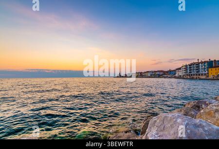 Sonnenuntergang über der adria in Piran, Slowenien. Alte antike und mittelalterliche Stadt, Blick von der Küste und vom Hafen. Alte Steine im Vordergrund, schön Stockfoto