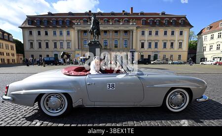 Weimar, Deutschland. 30. Mai 2025. Gerda und Peter Flohr starten die erste Etappe der ADAC Oldtimer Tour Thüringen in einem Mercedes-Benz 190 SL auf dem Platz der Demokratie in der Weimarer Innenstadt neben dem Residenzschloss und der Herzogin Anna Amalia Bibliothek. Fast 90 Fahrzeuge sind auf zwei Etappen in Thüringen unterwegs. Quelle: Martin Schutt/dpa/Alamy Live News Stockfoto