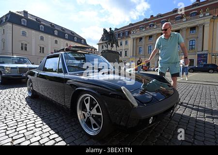 Weimar, Deutschland. 30. Mai 2025. Manfred Sitsch poliert seinen Porsche 914 vor Beginn der ersten Etappe der ADAC Oldtimer Tour Thüringen auf dem Platz der Demokratie in Weimars Innenstadt neben dem Residenzschloss und der Herzogin Anna Amalia Bibliothek. Fast 90 Fahrzeuge sind auf zwei Etappen in Thüringen unterwegs. Quelle: Martin Schutt/dpa/Alamy Live News Stockfoto