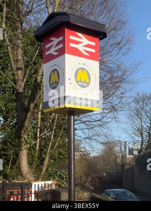 Der Bahnhof Huyton bedient Huyton in Merseyside, England. Der Bahnhof ist eine Kreuzung zwischen der Liverpool-Wigan-Linie und der nördlichen Strecke der Liverpool-Manchester-Linie, die kurz nach dem Bahnhof abzweigt. Es ist einer der geschäftigeren Bahnhöfe der Linien und in der Nähe des Einkaufszentrums und der Bushaltestelle. Stockfoto