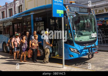 Passagiere, die in einem öffentlichen Elektrobus in Merida, Yucatan, Mexiko einsteigen Stockfoto