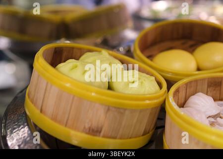 Verschiedene Dim Sum-Makros auf hölzernem Dampfgarer. Dampftechnik. Chinesisches Dessertessen. Dimsum mit Garnelen, Fisch und Fleisch. Gericht in einem Café. Hausgemacht. Lieferung Stockfoto