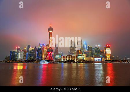 Hell erleuchtete Skyline von Lujiazui in der Nacht im Nebel gehüllt, Shanghai, China. Lujiazui ist das Finanzviertel von Shanghai. Stockfoto