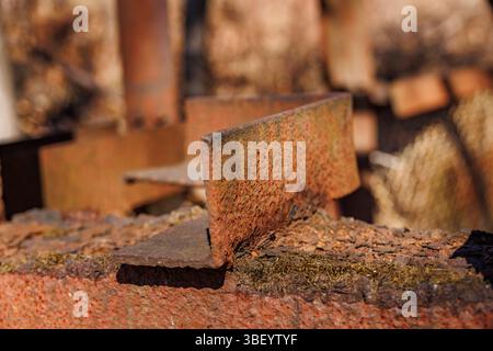 Nahaufnahme von verrosteten und verwitterten Stahlträgern in einem Schrottplatz im Freien oder in industriellen Umgebungen. Korrodierte Metallstrukturen und Zerfall werden hervorgehoben Stockfoto