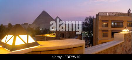 Blick auf die Pyramiden von Gizeh von der Dachterrasse in der Abenddämmerung, Gizeh, Kairo, Ägypten, Afrika Stockfoto