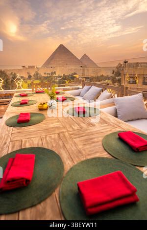 Blick auf die Pyramiden von Gizeh von der Dachterrasse während der goldenen Stunde, Gizeh, Kairo, Ägypten, Afrika Stockfoto