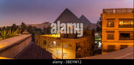 Blick auf die Pyramiden von Gizeh von der Dachterrasse in der Abenddämmerung, Gizeh, Kairo, Ägypten, Afrika Stockfoto
