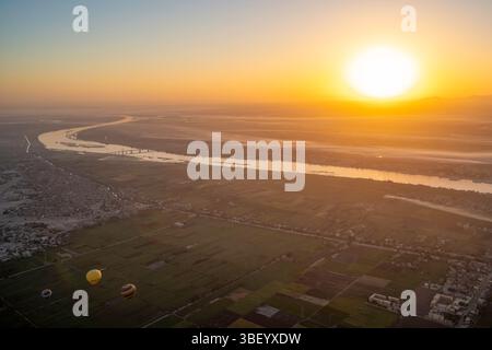 Blick auf den Nil vom Heißluftballon über Luxor bei Sonnenaufgang, Luxor, Ägypten, Afrika Stockfoto
